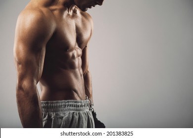 Cropped image of masculine young guy on grey background with copy space.  Workout and fitness theme. - Powered by Shutterstock