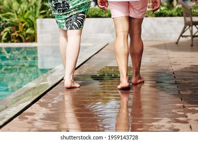 Cropped image of mature couple walking by swimming pool of hotel, summer vacation concept - Powered by Shutterstock