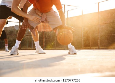 Cropped image of multiethnic men basketball players playing basketball at the sport ground