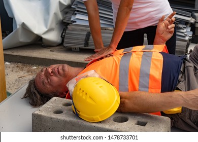 Cropped image of a paramedic's hands providing cardiopulmonary resuscitation (CPR) on a construction worker injured in an accident at work