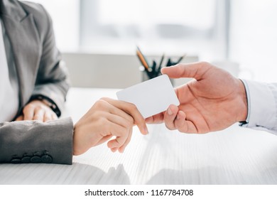 Cropped Image Of Patient Giving Id Card To Doctor In Clinic