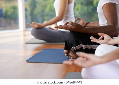 Cropped image of people meditating in lotus position