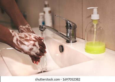 Cropped image of person washing hands at sink in bathroom, Coronavirus hand washing for clean hands hygiene Covid-19 spread prevention viral, bacterial infections. African-American woman washes hands.