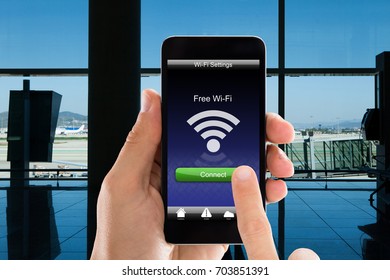 Cropped Image Of Person's Hands Using Free WiFi On Smart Phone In Airport