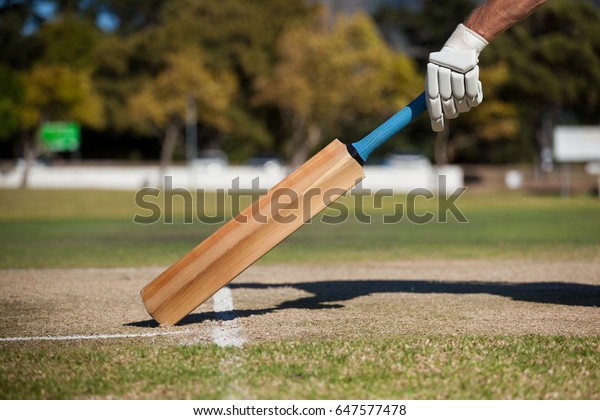Cropped\
image of player scoring run on cricket\
field