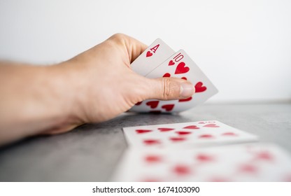 Cropped Image Playing Poker At Table In Home And Holding Playing Cards. Play Game During Home Quarantine For Coronavirus. Europe  