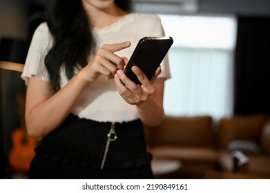 cropped image, Pretty young Asian female in casual outfit using her smartphone, text, message or chat with her friends. - Shutterstock ID 2190849161
