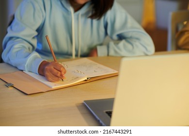 Cropped Image Of School Student Writing Essay In Notebook