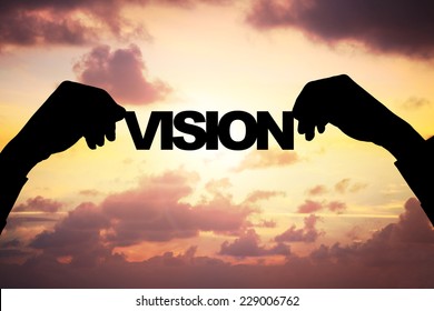 Cropped Image Of Silhouette Businessman's Hands Holding VISION Word Against Cloudy Sky During Sunset