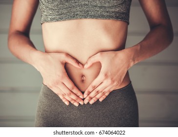 Cropped Image Of Slim Afro American Girl In Sportswear Showing Heart On Her Stomach