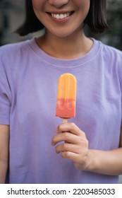 Cropped Image Of Smiling Asian Woman Wearing Purple T Shirt Holding Ice Cream