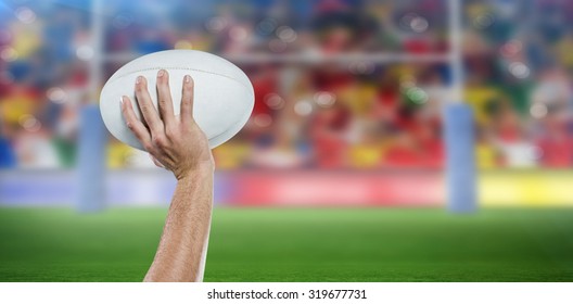 Cropped image of sports player holding ball against rugby stadium - Powered by Shutterstock