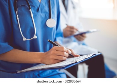 Cropped image of successful medical doctors making notes during the conference