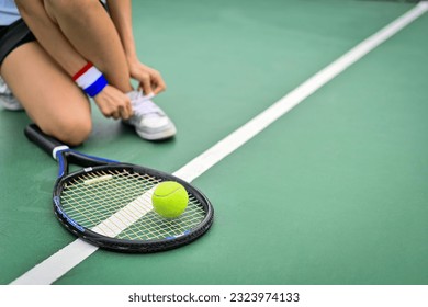 Cropped image of tennis player tying shoelace on court getting ready for match. Sport, active life, competition concept - Powered by Shutterstock