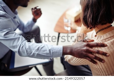 Cropped image of therapist touching shoulder of patient to support and reassure her