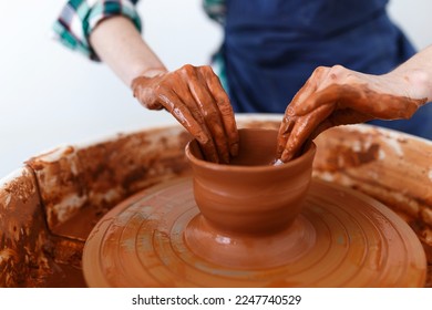 Cropped Image of Unrecognizable Female Ceramics Maker working with Pottery Wheel in Cozy Workshop Makes a Future Vase or Mug,Creative People Handcraft Pottery Class - Powered by Shutterstock
