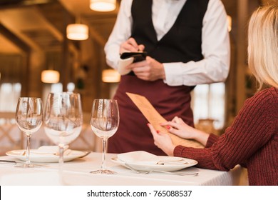 Cropped image of Waiter writing down the order of customer at the restaurant 