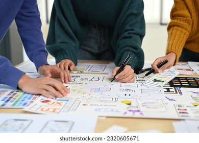 Cropped image of web developer team collaborating and planning template layout for mobile application in office - Powered by Shutterstock