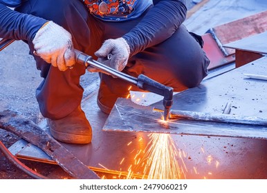 Cropped image of welder is cutting iron plate with acetylene gas welding torch machine for ship improvement work at shipyard - Powered by Shutterstock