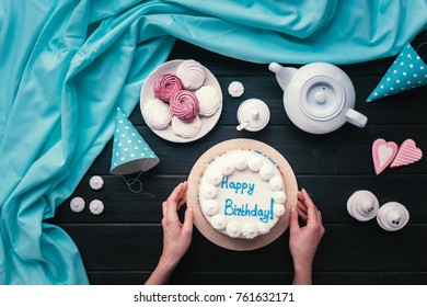 Cropped Image Of Woman Putting Birthday Cake On A Table