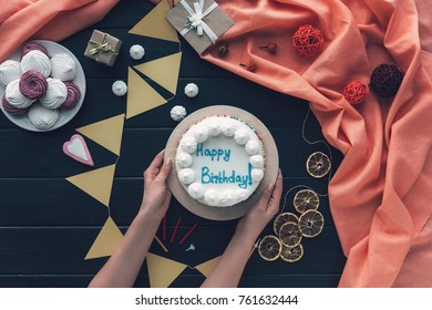 Cropped Image Of Woman Putting Birthday Cake On A Table