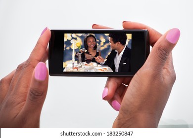 Cropped Image Of Woman Watching Video On Mobile Phone At Home