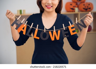 Cropped image of woman with word Halloween hanging on clothesline - Powered by Shutterstock