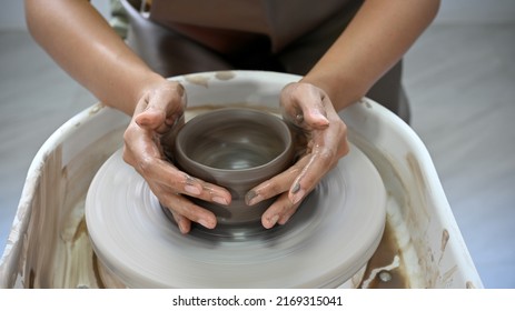 Cropped image, Woman's hands molding clay, making a clay pottery in the handicraft workshop. Artisan production concept - Powered by Shutterstock