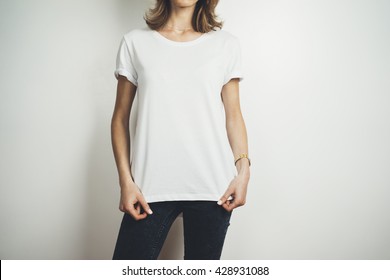 Cropped image of young hipster girl wearing blank white t-shirt and black jeans, mock-up of blank white t-shirt, white background
