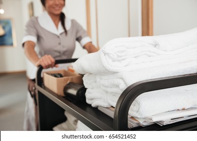 Cropped Image Of A Young Hotel Maid Bringing Clean Towels And Other Supplies