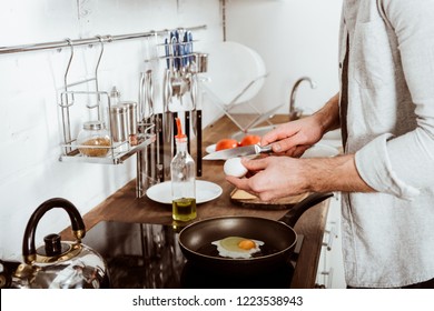 Cropped Image Of Young Man Cooking Scrambled Eggs On Breakfast In Kitchen 