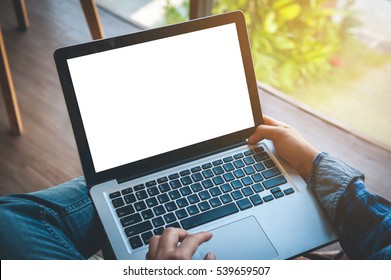 Cropped image of a young man working on his laptop in a coffee shop, rear view of business man hands busy using laptop at office desk, typing on computer sitting at wooden table - Powered by Shutterstock