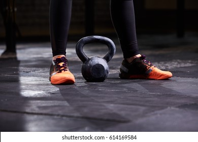 Cropped Image Of Young Woman, Legs In The Black Leggings, Orange Sneakers And Kettlebell. Workout At Gym