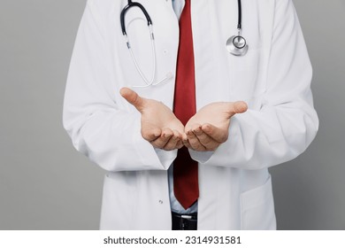 Cropped male doctor happy man wearing white medical gown suit work in hospital hold hands show empty palms offer something isolated on plain grey color background studio. Healthcare medicine concept - Shutterstock ID 2314931581