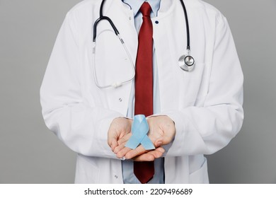 Cropped Male Doctor Man Wearing White Medical Gown Suit Work In Hospital Hold In Hands Blue Ribbon Aids Symbol Look Camera Isolated On Plain Grey Color Background Studio. Healthcare Medicine Concept