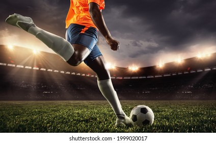 Cropped male soccer, football player practicing, attacking, kicking ball at sport match on sky background at stadium with flashlights. Sport competition. Action, motion, energy and dynamic concept. - Powered by Shutterstock