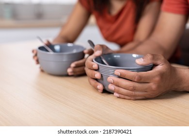 Cropped Millennial African American Man And Woman Hold In Hands Empty Plates At Table In Kitchen, Close Up. Starving Family Wait For Dinner. Diet And Hunger, World Food Crisis And Problems With Meal