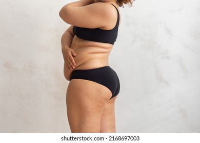 Cropped Overweight Fat Woman Pinching And Checking Volume Of Sides In Black Bikini. Excess Skin Problem After Childbirth. Edema Fibrosis Skin. Loosing Skin Turgor. Emphasizing Adiposity. Side View