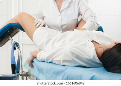 Cropped panorama of gynecologist examining a patient who is sitting in a gynecological chair. Female health concept.