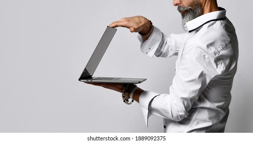 Cropped Photo About Business And Fashion Mature Bearded Man In White Shirt With Sly Smile Closed Laptop On Gray Background. Successful Completion Concept.