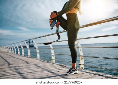 Cropped photo of athletic woman with prosthetic leg stretching at sunrise in the morning. Sport, motivation and fortitude concept. - Shutterstock ID 2177969257