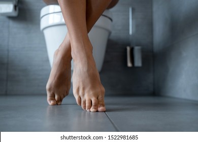 Cropped Photo Of A Caucasian Woman Sitting On The Toilet Seat