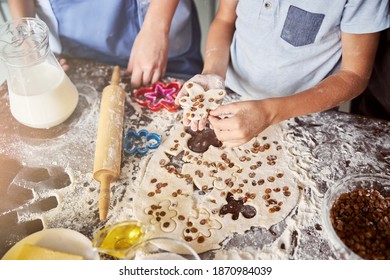 Cropped Photo Of Crafty Children Making Gingerbread Men Out Of Dough With Raisins On Kitchen Table