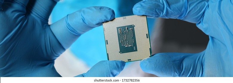 Cropped photo of engineer in protective mask and glasses showing microchip. Technology concept - Powered by Shutterstock