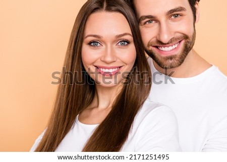 Cropped photo of funny young brown hairdo couple hug wear white outfit isolated on beige color background