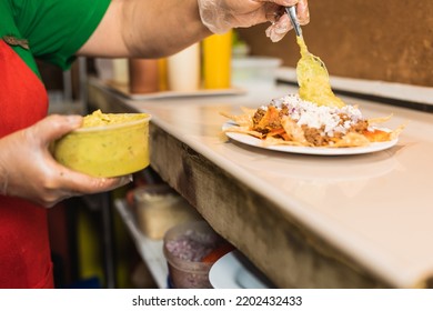 Cropped Photo Of The Hand Of A Woman Of A Restaurant Staff Adding Sauce To A Dish Of Nachos