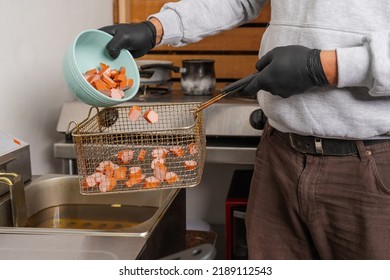 Cropped Photo Of The Hands Of A Cook Eating Slices Of Frankfurter In A Restaurant Kitchen Fryer