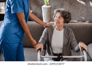 Cropped photo of happy pensioner grandmother elderly patient with walking frame with assistance of nurse caregiver at home. Walking after trauma injury - Shutterstock ID 2395115077