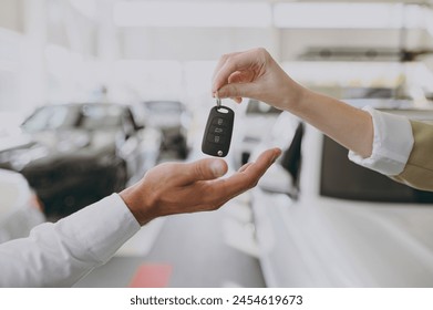 Cropped photo of male customer buyer client receive car keys fob keyless system from salesman choose auto want buy new automobile in showroom vehicle salon dealership store motor show. Sales concept - Powered by Shutterstock