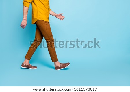 Cropped photo of man going towards empty space in brown shoes trousers pants trendy trend stylish isolated over blue pastel color background